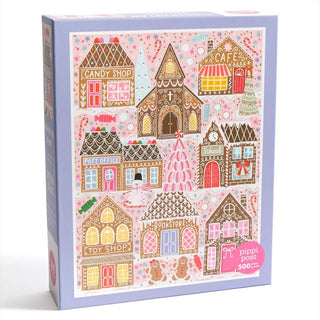 Gingerbread Square is a 500-piece jigsaw puzzle by Pippi Post, featuring illustrated gingerbread buildings—such as a candy shop, café, post office, school, toy shop, and bookstore—decorated festively with snowy details.