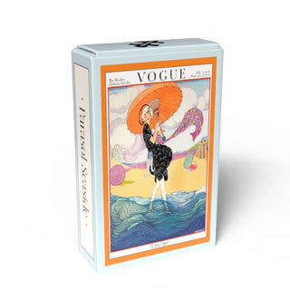 The Penny Puzzle Parasol Seaside | 99 Piece Jigsaw Puzzle comes in a rectangular box featuring a vintage Vogue cover of a woman with an orange parasol by the sea and "Parasol Seaside" on the side. Includes 99-piece minipuzzle inside.