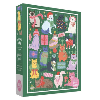 The Christmas Cats | 500 Piece Jigsaw Puzzle by Pippi Post features vibrant illustrations of cats dressed in winter and Christmas outfits, surrounded by gifts and festive decorations on a green background—making it a delightful holiday puzzle and the perfect gift for cat lovers.