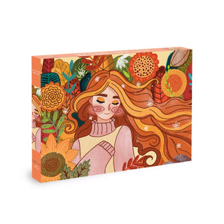 Step into enchanted worlds with the Olleo Puzzles “Autumn Breeze” 500 Piece Jigsaw Puzzle, featuring an illustrated box adorned with a warm autumn-toned image of a woman surrounded by colorful flowers and leaves.