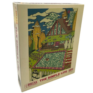 The Simple Life | 1,000 Piece Jigsaw Puzzle by Rolexa Puzzle Company features vibrant, surreal art of a house with a pool, garden, and trees. The title appears at the bottom of the colorful box.
