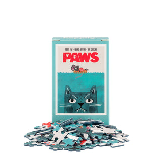 The Paws | 99 Piece Mini Jigsaw Puzzle by Happily Jigsaw Puzzles, designed by Nia Gould and inspired by the iconic Paws movie poster, features an illustration of a cat underwater and a mouse above, with mini jigsaw pieces scattered in front.