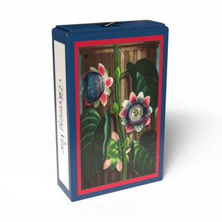 A rectangular box with a framed illustration of tropical flowers and large leaves on the front, set against a white background. The side of the box reads Penny Puzzle, making this Blooming Vine 99 Piece Jigsaw Puzzle reminiscent of a vintage Temple of Flora mini botanical puzzle.