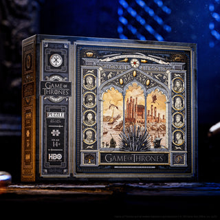 The theory11 Game of Thrones | 1,000 Piece Jigsaw Puzzle features detailed Iron Throne and character artwork, recommended for ages 14+, shown on a dark surface.