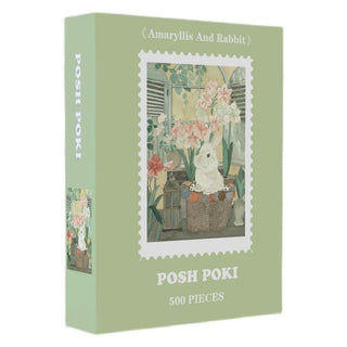 Posh Poki's "Amaryllis And Rabbit" is a 500 piece jigsaw puzzle in a green box, showing a white rabbit nestled among amaryllis flowers inside a basket.