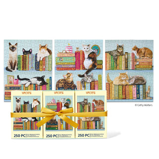 Three completed Cats On Books | 250 Piece Jigsaw Puzzle Set puzzles by WerkShoppe, each featuring charming felines perched on bookshelves, are displayed behind three puzzle boxes bundled with a yellow ribbon. Every 250-piece Cats On Books puzzle makes a purr-fect book lover’s gift or a delightful addition to any cat jigsaw puzzle collection.