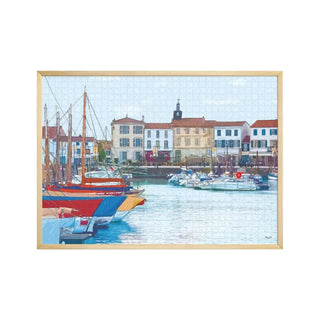 Enjoy assembling Aparté's "Port de La Flotte" 1,000 piece jigsaw puzzle, featuring a vibrant harbor scene with sailboats and colorful buildings reminiscent of a framed painting.