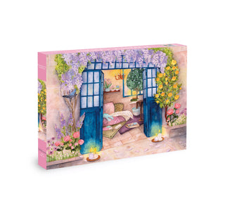 The Romantic Garden | 500 Piece Jigsaw Puzzle by Olleo Puzzles features a vibrant illustrated box with blue doors, flowers, candles, and cozy décor—evoking the enchanting charm of a winter garden.