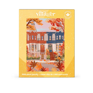 Villager Puzzles’ Touring Montreal 1,000 Piece Jigsaw Puzzle comes in a yellow box with English and French text, and showcases a colorful illustration by a Canadian artist featuring Montreal row houses in autumn, complete with fallen maple leaves and a bicycle out front.