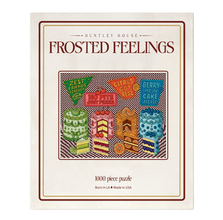 Frosted Feelings 1,000-piece jigsaw puzzle box featuring four colorful cakes, each topped with a sign displaying puns about citrus and berries.