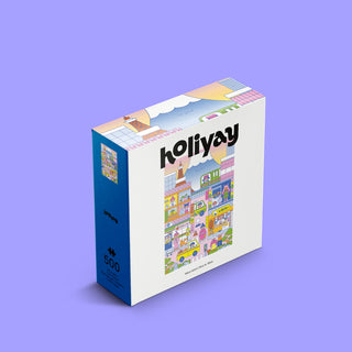 A square Busy in Tokyo | 500 Piece Jigsaw Puzzle box featuring an illustrated Tokyo street scene with shops, people, and Mount Fuji in the background.