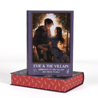 The Evie & Villain | 250 Piece Jigsaw Puzzle features an illustrated couple in a forest, sitting atop a red, sword-patterned, book-shaped keepsake box.