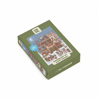 Box for a Croissant et Café Chaud | 99 Piece Jigsaw Puzzle by Heol Editions, featuring an illustration of a café street scene with a person riding a bicycle past a croissant and coffee.
