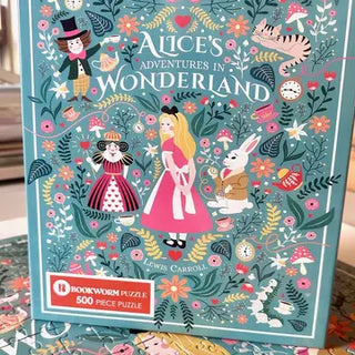 Alice’s Adventures in Wonderland | 500 Piece Jigsaw Puzzle box featuring Alice, the White Rabbit, the Queen of Hearts, and the Cheshire Cat surrounded by floral illustrations and teacups.