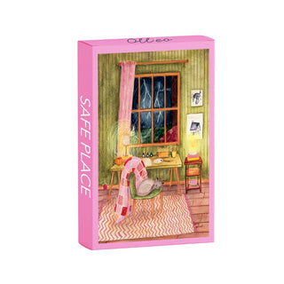The Olleo Puzzles Safe Place | 99 Piece Jigsaw Puzzle comes in a pink box with Louise Gobinet’s cozy room illustration, featuring a chair, desk, and stormy window. “SAFE PLACE” is marked on the side.