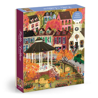 The Galison Joy Laforme Falls Hollow 1,000 Piece Jigsaw Puzzle showcases a delightful illustration by Joy Laforme, depicting a gazebo surrounded by vibrant autumn scenery in a charming village with houses, trees, people, and festive seasonal decorations—an ideal choice for lovers of New England fall puzzles.