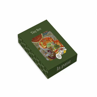 A green rectangular la pauz Tiny Box 99 piece jigsaw puzzle box featuring a central illustration of a table setting and the number 11 on the front.