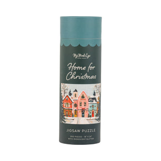The Home For Christmas | 500 Piece Jigsaw Puzzle by My Mind’s Eye comes in a cylindrical container and features an illustration of colorful houses in a snowy winter scene. This delightful holiday puzzle dazzles with iridescent glitter, making it the perfect festive activity for the season.