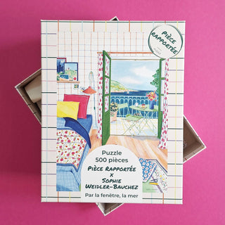 Enjoy the "Par La Fenêtre, La Mer" 500 piece jigsaw puzzle by Pièce Rapportée, featuring an open window view of the sea and a vibrant bedroom on a pink background.