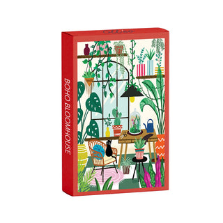 Discover the Boho Bloomhouse | 99 Piece Jigsaw Puzzle by Olleo Puzzles, featuring an illustrated room brimming with plants, chairs, books, and a black cat perched on a table. The box reads BOHO BLOOMHOUSE—an ideal choice for cat puzzle fans and lovers of cozy decor.