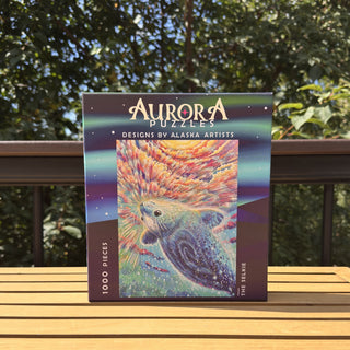 Aurora Puzzles' "The Selkie" is a 1,000 piece eco-friendly jigsaw puzzle featuring vibrant seal art by an Alaska artist—ideal for Harbor Seal puzzle fans.