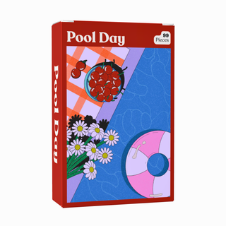 The Pool Day | 99 Piece Jigsaw Puzzle by Puzzledly features a delightful poolside scene complete with cherries, daisies, a pink float, and a checked towel. This pocket-sized puzzle is perfect for on-the-go fun or as a charming mini puzzle to brighten your day.