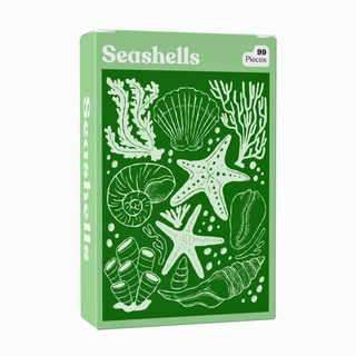 The Puzzledly Seashells | 99 Piece Jigsaw Puzzle comes in a green box adorned with illustrations of seashells, starfish, coral, and urchins on the front. This mini puzzle is perfect for on-the-go fun.