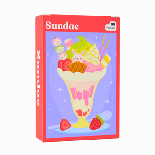 The Sundae | 99 Piece Jigsaw Puzzle by Puzzledly is a vibrant, pocket-sized puzzle box showcasing an illustrated ice cream sundae topped with fruit, cookies, and candy, all set against a pastel background.