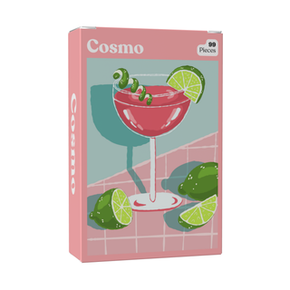 Introducing the Cosmo | 99 Piece Jigsaw Puzzle by Puzzledly: a pocket-sized puzzle box featuring an illustration of a pink cocktail in a glass, garnished with lime wedges and a lime twist, and labeled “Cosmo.” With ribbon-cut pieces, this stylish mini decor offers a fun and chic challenge.
