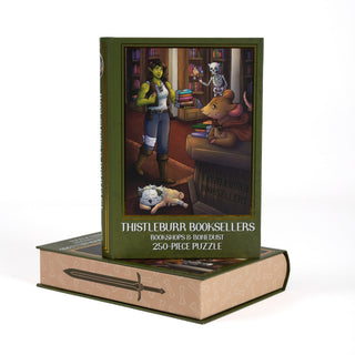 Thistleburr Booksellers 250 Piece Jigsaw Puzzle box showing a green-skinned fantasy character, a skeleton with a torch, a mouse, and a sleeping dog in a library, set on a sword and bone patterned box.
