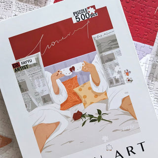 Stay Together by Seren Art is a 500-piece puzzle featuring two people in robes enjoying tea in bed with a red rose and newspapers, plus white and orange pillows. Finished size: 15 x 20.9. Perfect for cozy puzzle lovers.