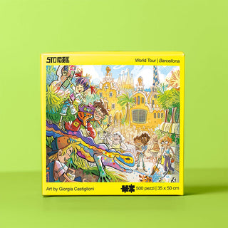 The StoPuzzle Barcelona | 500 Piece Jigsaw Puzzle features cartoon characters and iconic Gaudí-inspired sites like the Sagrada Família, with a lively mosaic lizard scene. Finished size: 35 x 50 cm.