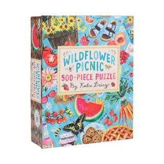 The image displays the Wildflower Picnic | 500 Piece Jigsaw Puzzle by Chronicle Books, featuring vibrant illustrations of picnic foods, flowers, and summer items.