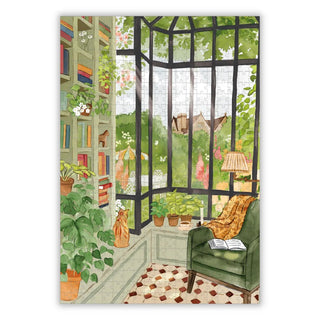 A cozy reading nook with a green armchair, books, houseplants, and garden views—just like the inviting scene on the Reading Break | 500 Piece Jigsaw Puzzle by Aparté.