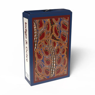 A blue box labeled “Indigo & Ochre | 99 Piece Jigsaw Puzzle” from Penny Puzzle features an abstract, earthy-toned pattern with curved shapes and dotted lines on the front, reminiscent of E. A. Séguy’s signature style often seen in Art Deco puzzles and vintage mini puzzles.