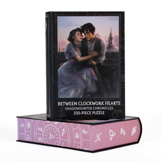 Between Clockwork Hearts 250 Piece Jigsaw Puzzle box featuring a Charlie Bowater illustration of a couple on a rooftop, with a pink base decorated with circular symbols.