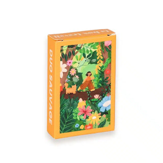 A rectangular orange box labeled "Duo Sauvage | 99 Piece Jigsaw Puzzle" by Trevell features colorful plants, flowers, and a person with a dog in a forest scene on the front; contains 99 illustrated puzzle pieces.