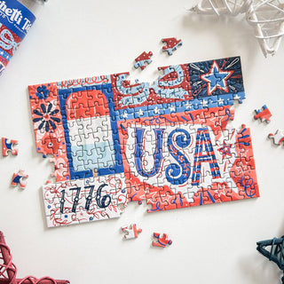 Celebrate the USA’s 250th anniversary with Spaghetti Tree’s Red White and Blue | 150 Piece Jigsaw Puzzle—featuring “USA,” 1776, stars, and patriotic designs. A few pieces remain to finish this festive mini puzzle challenge!.