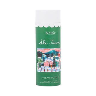 The Ski Town | 500 Piece Jigsaw Puzzle by My Mind’s Eye comes in a tall cylindrical box featuring an illustration of a snowy ski town with skaters. This iridescent glitter puzzle contains 500 sparkling pieces for a magical puzzling experience.