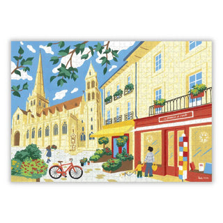 Autun Cathedral | 1,000 Piece Jigsaw Puzzle by Aparté features a vibrant European street scene with yellow buildings, a red bicycle, potted plants, and people strolling in the sun—ideal for puzzle enthusiasts.