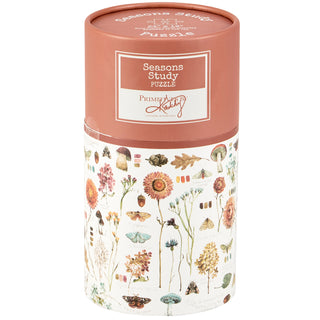 The Seasons Study | 500 Piece Jigsaw Puzzle by Primitives by Kathy comes in a cylindrical box decorated with watercolor art of flowers, leaves, mushrooms, and insects—a delightful gift for nature lovers.