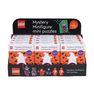 Showcase a display box of Chronicle Books’ LEGO Mystery Minifigure (Halloween Edition) 126-piece jigsaw puzzles, presented in festive Halloween-themed packaging. The set contains six individual boxes, each labeled to reveal one of six possible collectible designs. Every puzzle offers the excitement of assembling a surprise LEGO minifigure with a spooky Halloween twist—ideal for anyone eager to discover which mystery mini puzzle they’ll build next!.