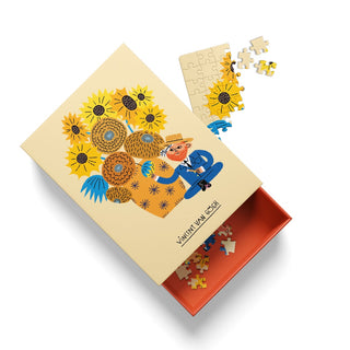 A 99-piece jigsaw puzzle from Ohh Deer, featuring an illustration of Vincent Van Gogh painting sunflowers in a whimsical style inspired by Teresa Bellón; several pieces from this mini puzzle are scattered outside the box.