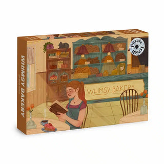 The Whimsy Bakery | 500 Piece Jigsaw Puzzle by Trevell features a cozy bakery scene with a woman reading, shelves of bread, and “Whimsy Bakery” on the counter.