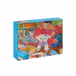 The Afternoon Tea | 500 Piece Jigsaw Puzzle box, featuring an illustration of a person reading a newspaper with a coffee cup and a small white dog.
