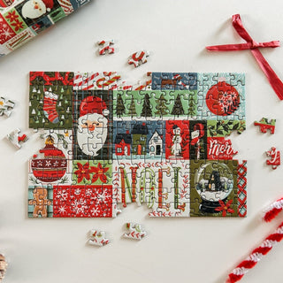The Spaghetti Tree Merry Medley | 150 Piece Jigsaw Puzzle features a partially completed Christmas-themed design with festive images and the word NOEL, surrounded by loose pieces on a white surface—ideal for fans of mini puzzles or anyone looking for a portable holiday activity.