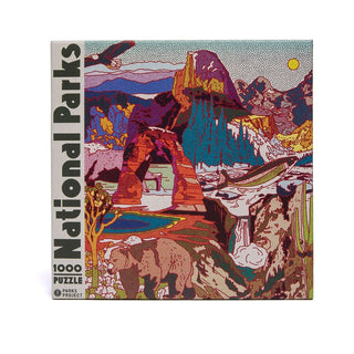 The Parks Project National Parks Collage is a 1,000-piece jigsaw puzzle featuring a vibrant illustrated landscape with mountains, a bear, a bird, and park scenery.