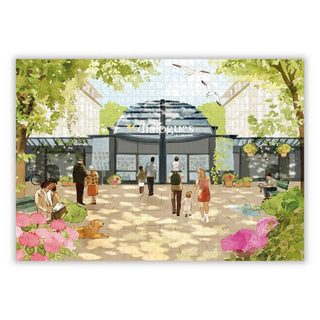 The Aparté Librairie Dialogues 1,000 Piece Jigsaw Puzzle features an outdoor scene with people and a dog in front of a “dialogues” bookstore, shaded by trees and decorated with flowers and hanging plants.