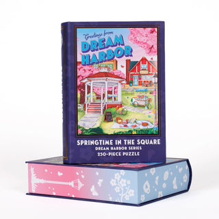 Beautifully presented atop a book-shaped keepsake box, the Kingdom of Threads Dream Harbor Springtime in the Square 250-piece jigsaw puzzle features a vibrant illustration of a house and garden—making it a perfect decorative treasure for fans of charming scenes like the beloved Strawberry Patch Pancake House.