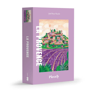La Provence | 500 Piece Jigsaw Puzzle by Piecely features Ellen Gözel-Niehoff’s lavender-colored cover with a charming village and lavender fields.